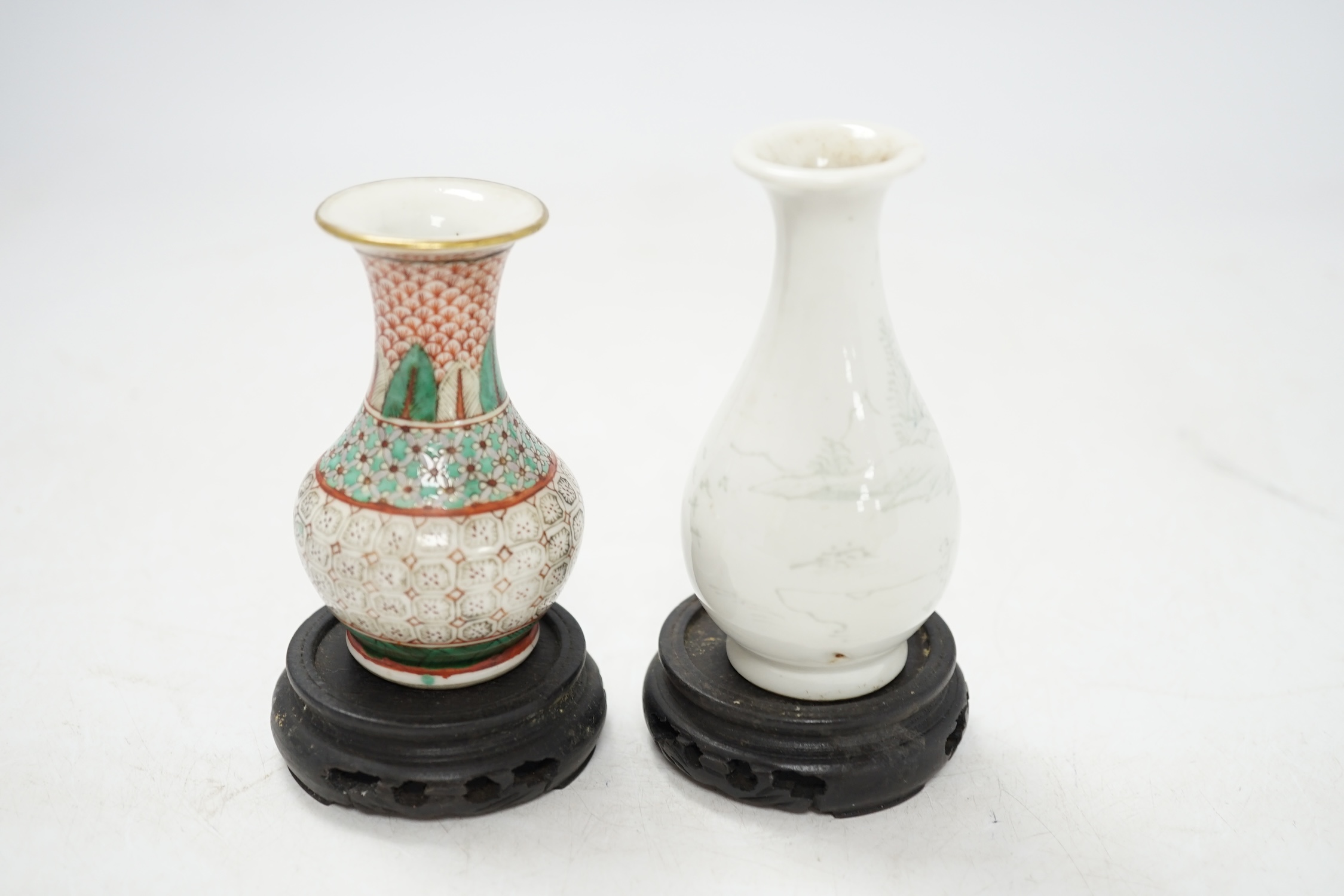 Two miniature Chinese porcelain vases, on hardwood stands, largest 9cm high. Condition - fair